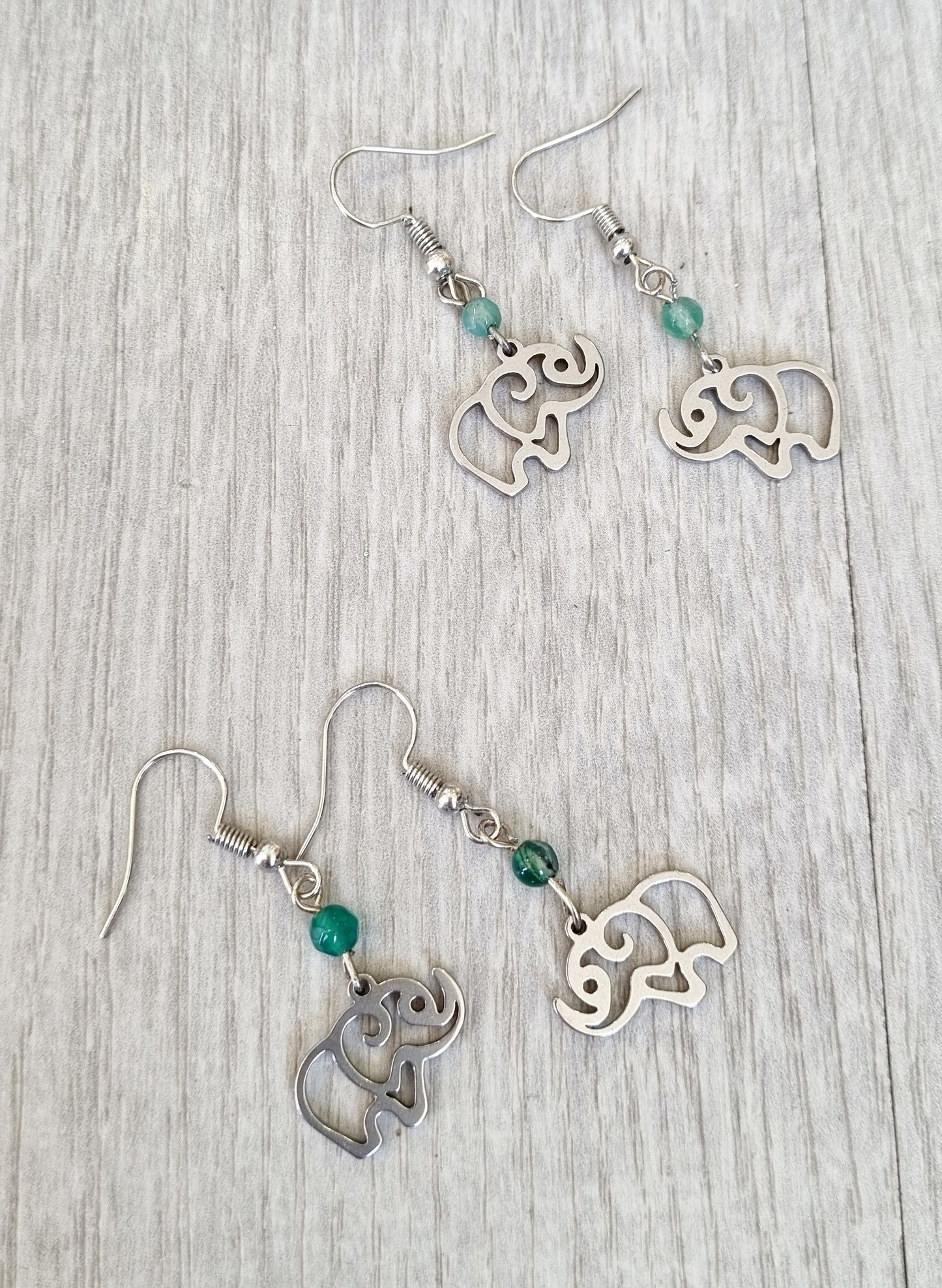 Pendientes de acero con cierre de gancho y colgante de elefante. Puedes elegir el modelo sencillo o con mini bola de piedra natural a elegir.