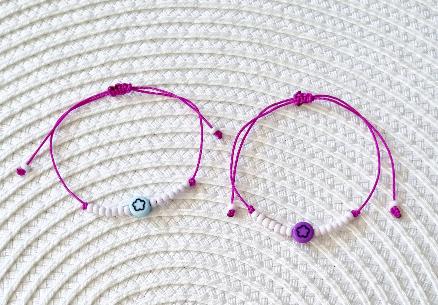 Pulsera realizada con hilo morado, con cierre de macramé y mini bolas de rocalla en tono blanco roto mate. Póntela en la muñeca izquierda para atraer energía positiva a tu vida.