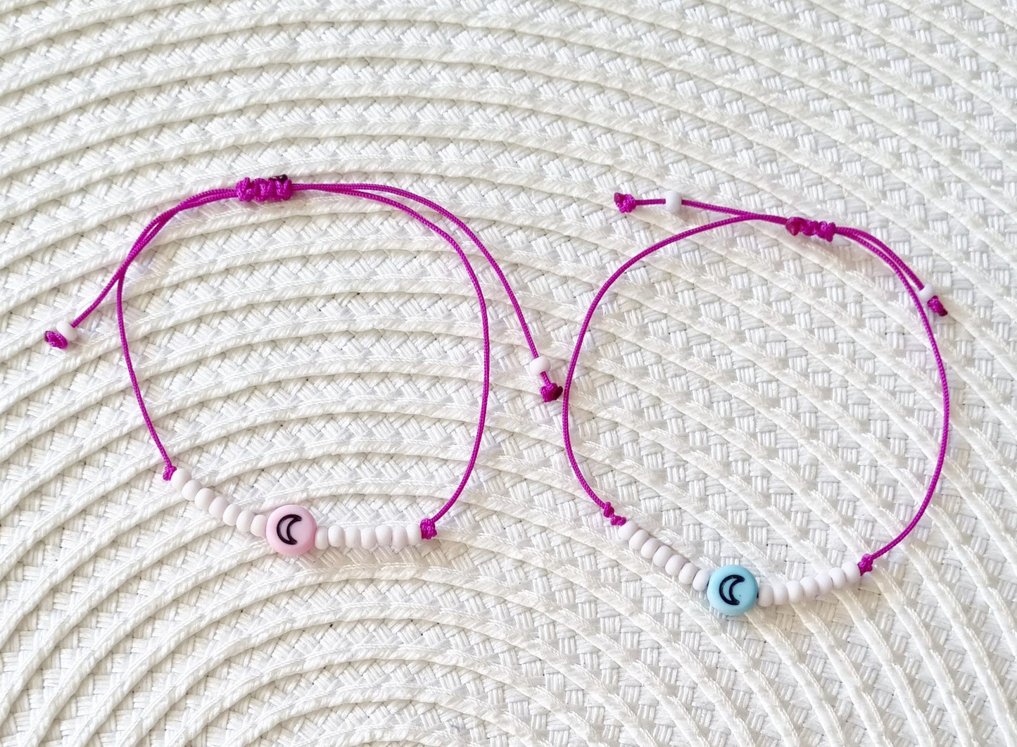Pulsera realizada con hilo morado, con cierre de macramé y mini bolas de rocalla en tono blanco roto mate. Póntela en la muñeca izquierda para atraer energía positiva a tu vida.