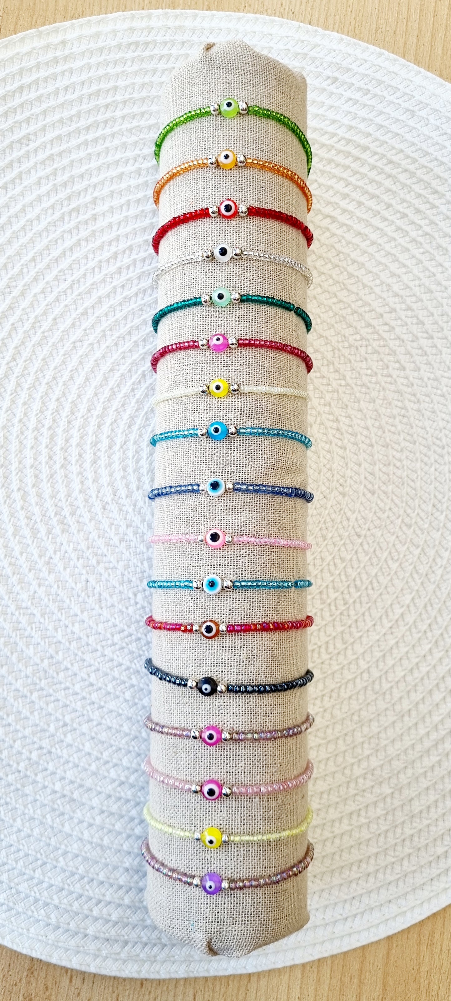 Pulsera elástica de protección ojo turco mini. Realizada con mini bolas de rocalla en tonos brillantes, entre piezas de acero y detalle de ojo turco en distintos colores.