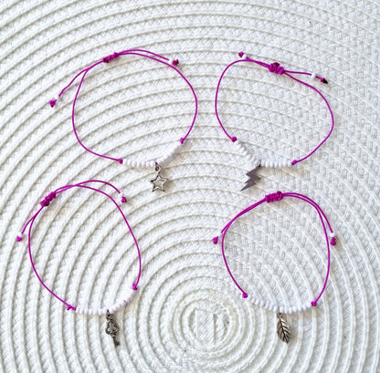 Pulsera realizada con hilo morado, con cierre de macramé y mini bolas de rocalla en tono blanco roto mate.   Póntela en la muñeca izquierda para atraer energía positiva a tu vida.