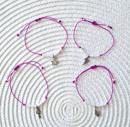 Pulsera realizada con hilo morado, con cierre de macramé y mini bolas de rocalla en tono blanco roto mate.   Póntela en la muñeca izquierda para atraer energía positiva a tu vida.