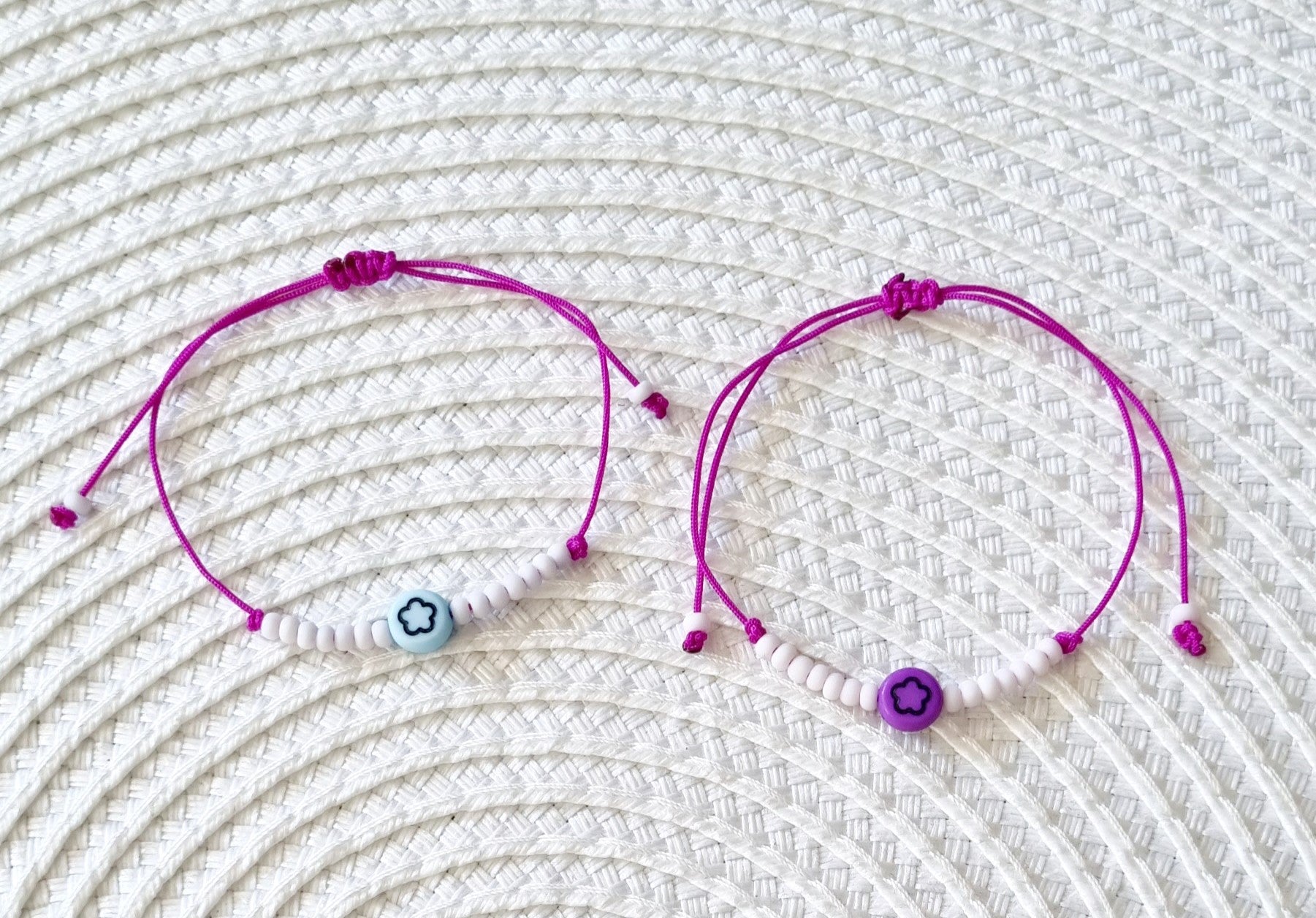 Pulsera realizada con hilo morado, con cierre de macramé y mini bolas de rocalla en tono blanco roto mate.   Póntela en la muñeca izquierda para atraer energía positiva a tu vida.